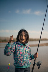 niña 7-12 pescando y disfrutando con caña en rio Paraná en hermoso atardecer