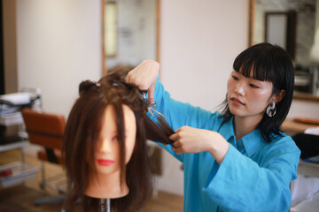 髪を切る練習する美容師　イメージ