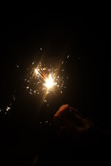 Hand holding sparkler, black backround/night