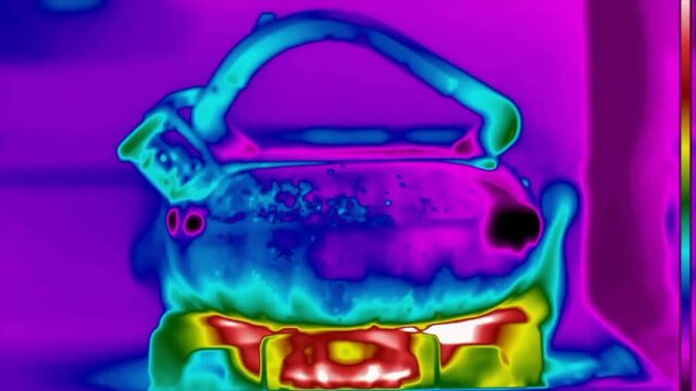 An HD FLIR thermal imaging shot of kettle slowly changing colors as the temperature increases and the water boils.