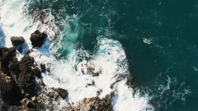 Foamy Waves Crashing On Rocky Coast Of Adriatic Sea In Polignano a Mare, Apulia, Italy. aerial top-down