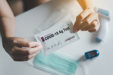 Woman using a covid-19 self test rapid antigen testing kit at home