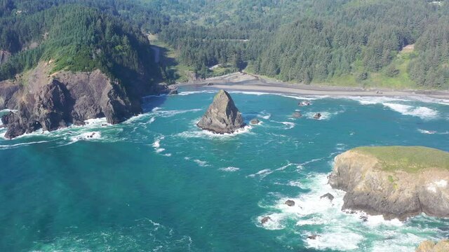 The Pacific Ocean washes against a sea stack and the scenic coast of southern Oregon. This rugged and rocky part of the Pacific Northwest is found along the Samuel H. Boardman State Scenic Corridor.