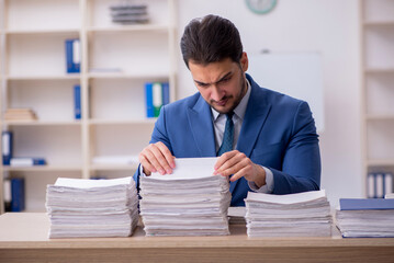 Young male employee unhappy with excessive work in the office