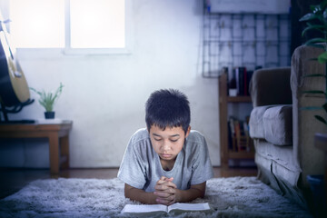 Boy reading Bible in home, Discipleship studying the word of god in home.