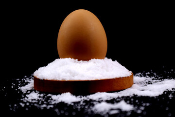 An egg above the salt or salty egg in black background in HD size