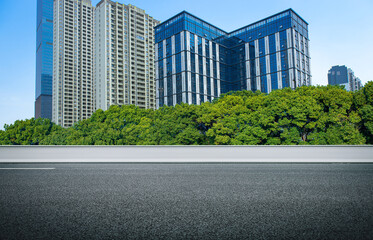 The black asphalt road next to the city's high-rise buildings