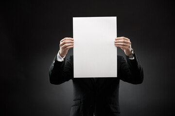 Businessman showing empty white paper