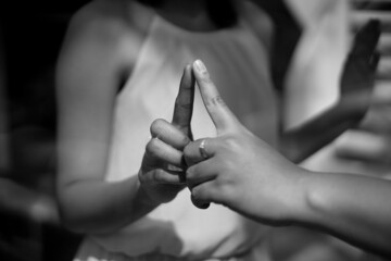 bride and groom holding hands like ET  separate by glasses in black and white