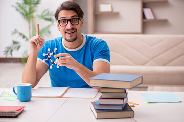 Young male student physicist studying molecular model
