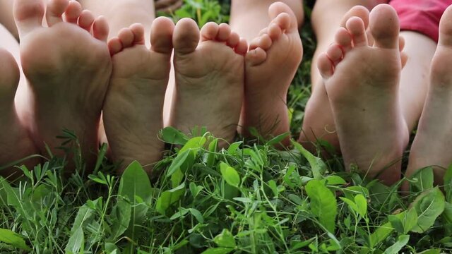 kids bare soles on grass, hardening foot concept