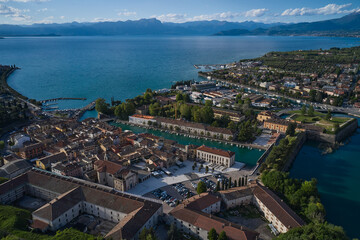 Obraz premium Aerial panorama of the city of Peschiera del Garda on Lake Garda, Italy. Aerial view of a tourist town in Italy. The city of peschiera del garda at sunset. Italian resorts on Lake Garda.