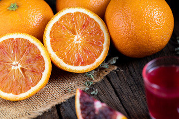 Sliced Sicilian Blood oranges fruits over old dark wooden background.