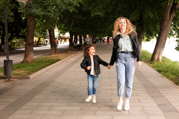 Obraz premium The mom and little girl walk together along the waterfront