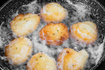 Cooking fried zucchini fritters in the pan with oil