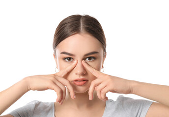 Fototapeta premium Beautiful young woman doing facial yoga on white background