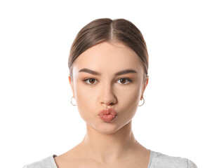 Obraz premium Beautiful young woman doing facial yoga on white background