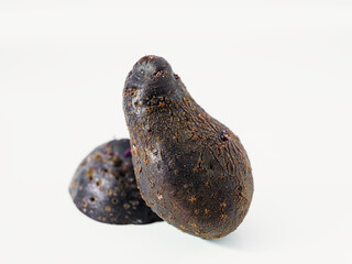 Two Dark Purple Shetland Black Potatoes Isolated on White Background. Vegetable still life for food from Hügelkultur no-dig raised bed.