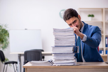 Young businessman employee and too much work in the office