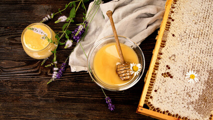 Honey in a jar and a honeycomb on wooden background.