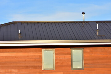 Fototapeta premium Detail of modern house with cedar cladding and corrugated metal roof.