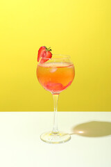 Glass of fresh summer cocktail against yellow background
