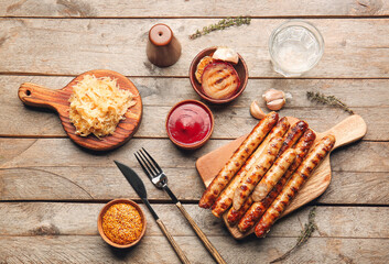 Board with tasty grilled sausages, sauerkraut and sauces on wooden background