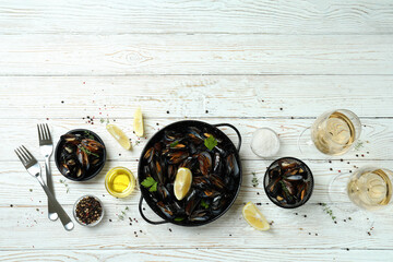 Concept of delicious food with mussels on white wooden table