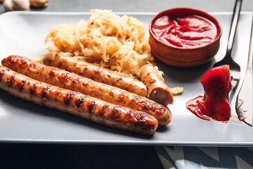 Plate with tasty sauerkraut, grilled sausages and sauce, closeup