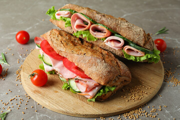 Concept of tasty eating with ciabatta sandwiches on gray textured table