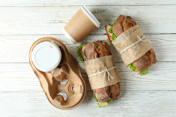 Ciabatta sandwiches and coffee cups on white wooden table