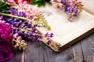 Colorful lupine flowers on the rustic background in atmospheric environment. Selective focus. Shallow depth of field.
