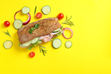 Ciabatta sandwich and ingredients on yellow background
