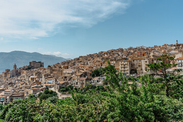 Fototapeta premium Caccamo, Sicily, Italy. View of popular hilltop medieval town with impressive Norman castle and surrounding countryside.Italian landscape.Picturesque village on hill with mountains in background.