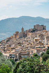 Obraz premium Caccamo, Sicily, Italy. View of popular hilltop medieval town with impressive Norman castle and surrounding countryside.Italian landscape.Picturesque village on hill with mountains in background.