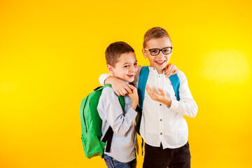 Two school friends stand in an embrace and smile