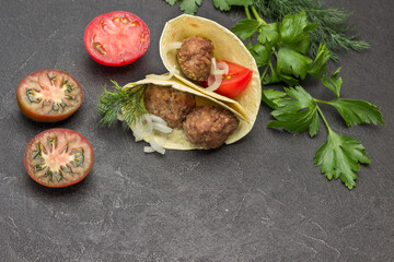 Pita with meatballs and onions.