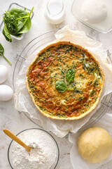 Spinach tart and ingredients on light background