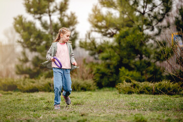 Little girl with doggy training ring on nature