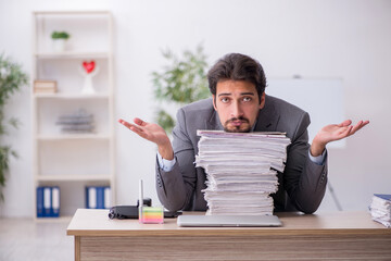 Young male employee and too much work in the office