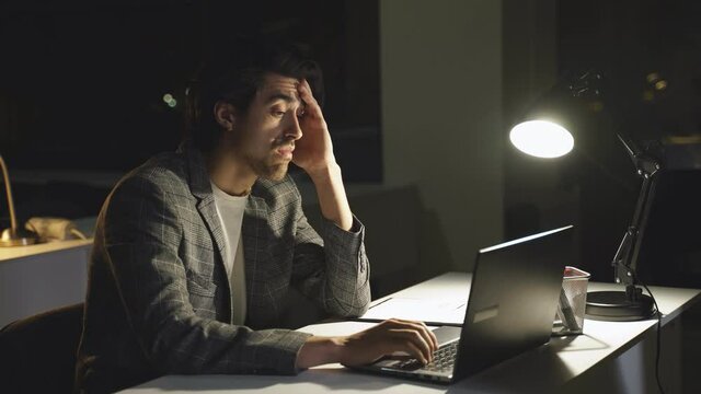people work alone in the office, staying up late. A young manager works with a laptop at night in the office. business, deadline, network concept