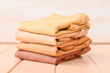 Stack of baby clothes on color wooden background