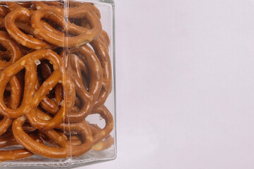 Pretzel cracker in a glass jar on white background