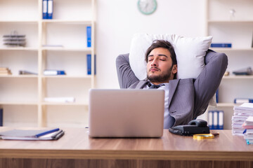 Young male employee in oversleeping concept