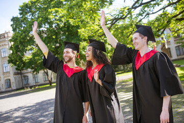 A group of graduates in the park feeling great and excited