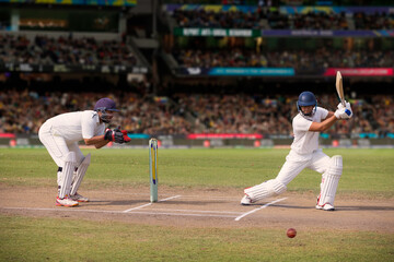 Cricketer batsman hitting a shot during a match on the pitch - obrazy, fototapety, plakaty