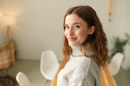 Curious young woman looking back with a friendly smile