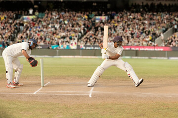  Cricketer, batsman hitting a shot at the crease during a match