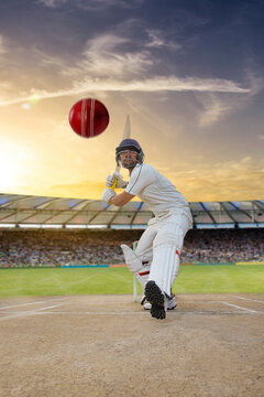 Cricketer batsman hitting a shot during a match on the pitch