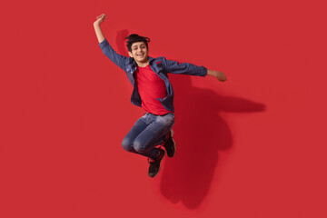 A TEENAGER HAPPILY JUMPING AND POSING IN FRONT OF CAMERA